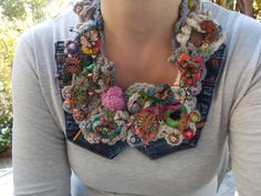 a woman wearing a crocheted necklace with flowers on it's collar and buttons