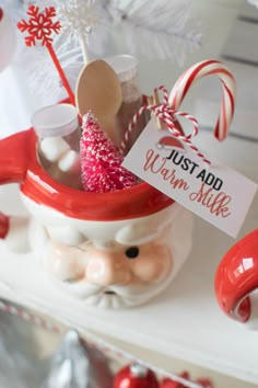 a santa claus mug filled with candy canes and marshmallows for christmas