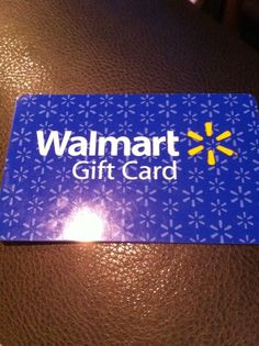 a blue walmart gift card sitting on top of a brown leather table next to a light