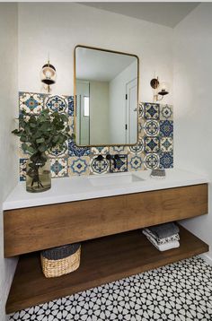 a bathroom sink with a mirror above it and a potted plant on the counter