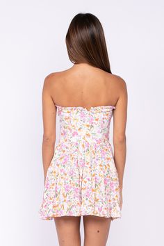 STYLE INFORMATION: The Garden Charm Wildflower Floral Strapless Dress is the print dress you need in your closet! This eye-catching strapless mini dress is entirely covered in pink, orange, green, and yellow floral print and is super flattering with its strapless bustier bodice with self-tie and a sweetheart neckline (and hidden no-slip strips), and corset-inspired seaming. Flattering fitted waist tops a flaring ruffle mini skirt. Partially lined. DETAILS & CARE: Rayon/Polyester. Machine wash co Spring Mini Dress With Sweetheart Neckline And Lined Bodice, Pink Mini Dress With Lined Bodice, Spring Ruched Mini Corset Dress, Garden Party Mini Dress With Corset Back, Strapless Spring Mini Dress With Ruched Bodice, Strapless Mini Dress With Ruched Bodice For Spring, Fitted Strapless Corset Dress With Floral Print, Fitted Strapless Mini Dress With Smocked Bodice, Spring Strapless Mini Dress With Ruched Bodice