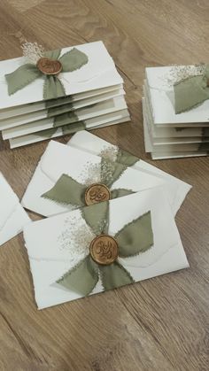 several folded cards with buttons on them sitting on a wooden floor next to each other