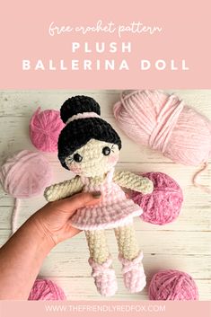 a crocheted doll is being held up by someone's hand with yarn balls in the background