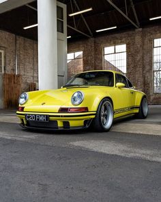 a yellow porsche parked in an empty garage