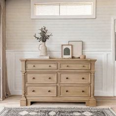 a white room with a dresser and rug