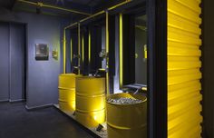 a room with yellow barrels in it and some lights on the side of the wall