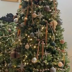 a christmas tree decorated with seashells and starfish in gold, silver and brown colors