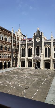 an old building with a basketball court in front of it