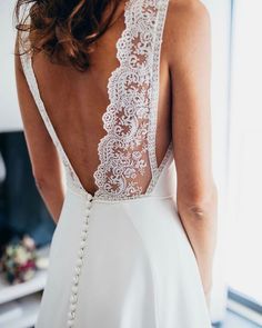 the back of a woman's wedding dress, with pearls on the waist and neckline