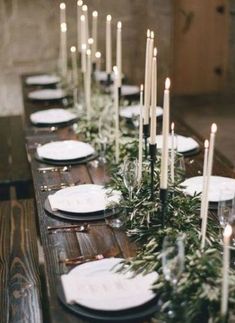 a long table with candles and plates on it