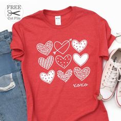 a t - shirt with hearts on it next to jeans and white tennis shoes in the background