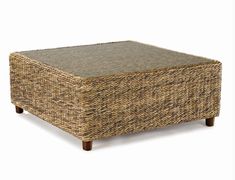 a square wicker coffee table with an upholstered top and wooden legs, against a white background