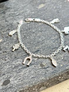 We all need some luck 🍀  Add a touch of charm and protection to your style with our Sterling Silver 925 Lucky Charms Bracelet.  This elegant bracelet features 7 dangling charms, each symbolizing luck and protection: an owl for wisdom, a four-leaf clover for good fortune, the number 7 for prosperity, an evil eye for warding off negativity, and an elephant for strength.  Crafted with a durable, resistant chain, this bracelet is perfect for daily wear, combining style and spiritual significance.  A must-have‼️for those who believe in the power of lucky charms!  We also have the lucky charms Ring available ☺️ Authentic sterling silver 925 Made in mexico Good Luck Charms Bracelet, Silver Hypoallergenic Jewelry For Good Luck, Adjustable Good Luck Charm Bracelet, Hypoallergenic Silver Good Luck Jewelry, Spiritual Sterling Silver Dangle Bracelets, Sterling Silver Spiritual Dangle Bracelets, Hypoallergenic Sterling Silver Dangle Bracelets, Silver Symbolic Bracelets With Dangling Charms, Silver Sterling Charm Bracelet With Dangling Charms