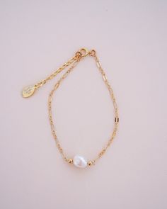 "The Delaney Pearl Bracelet features a beautiful gold-filled specialty link chain with a 1\" attached extender, making it easily adjustable to fit any wrist size. It is handcrafted with care and attention to detail, ensuring the highest quality and durability. The freshwater pearl with bead accents is hand wire-wrapped onto the chain, adding a touch of elegance and sophistication to this dainty gold bracelet. The Delaney Pearl Bracelet is the perfect complement to the other pieces in the Delaney Luxury Dainty Pearl Bracelets, Elegant 14k Gold Filled Bracelet With Extender, Dainty Wedding Jubilee Charm Bracelet, Dainty Gold Bracelet With Extender, Minimalist Charm Bracelet With Adjustable Chain For Wedding, Minimalist Adjustable Chain Charm Bracelet For Wedding, Gold Bracelet With Pearl Charm, 14k Gold Filled, Dainty Gold Bracelets With Pearl Chain, Minimalist Wedding Charm Bracelet With Adjustable Chain