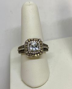 a white ring with brown and yellow diamonds on it's side, sitting on top of a napkin