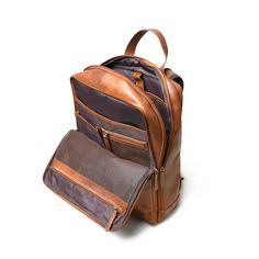 Crafted from buffalo top grain leather, this backpack is a perfect blend of fashion and functionality. Handcrafted with smooth finishing using premium top-grain leather, it's an ideal companion for trekking or any adventure. This Transit backpack doubles as a laptop bag for office or college, featuring two large central compartments with multiple pockets for organized storage. The canvas lining inside and at the back adds a rugged touch. With a strong durable handle and shoulder straps, it ensur Rugged Laptop Bag For Travel, Leather Backpack For Business Trips With Luggage Sleeve, Leather Backpack With Luggage Sleeve For Business Trips, Brown Leather Backpack For Business Trips, Business Backpack With Waxed Finish, Leather Backpack For Business Trips, Organized Storage, Buffalo Leather, Top Grain Leather