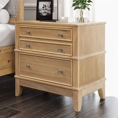 a bedroom scene with focus on the dresser and bed side table in the foreground