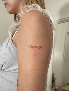 a woman with a tattoo on her arm that says, christ for life in red ink