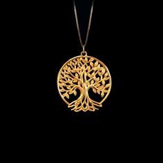 a gold tree of life pendant on a black background