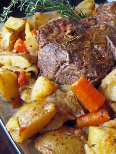 a close up of a plate of food with meat and vegetables on it, including potatoes and carrots