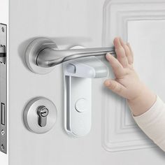 a baby's hand is on the handle of a door lock that has been opened