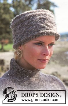 a woman wearing a knitted hat and scarf on top of her head with trees in the background