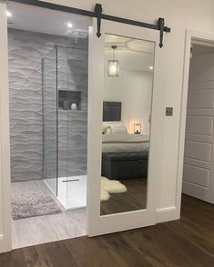 an open door leading to a bedroom with a bed in the background and a bathroom behind it