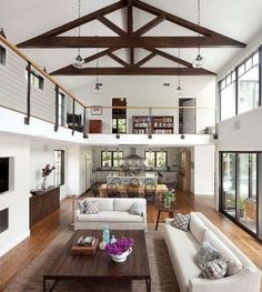 a living room filled with furniture and lots of windows on top of the walls,