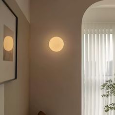 two round lights are hanging on the wall