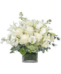 a vase filled with white flowers and greenery