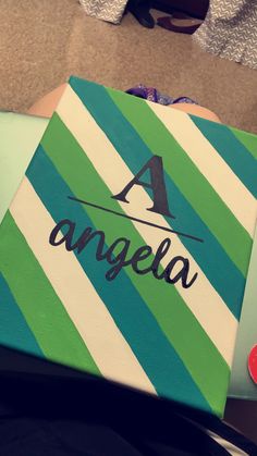 an acrylic painted canvas with the word angeloa in black and green stripes