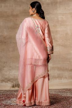 Peach kurta with placement floral embroidery. Comes with sharara pants and dupatta.
Components: 3
Fabric: Chanderi, Organza
Neckline: Round
Sleeve Length: Bracelet
Color: Peach
Embroidered
Kurta with side criss cross tie-up
Sheer panels
Sharara with embroidered hem
Dupatta with tassels
Closure: Kurta: Front loop buttons - Aza Fashions Designer Kurta Sets For Women, Kurta Sets For Women, Sharara Pants, Kurta Sharara Set, Kurta Sharara, Designer Kurta, Round Bracelet, Embroidered Hem, Sharara Set