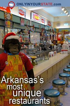 a person in an apron and santa hat standing next to a bar with stools