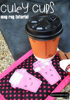 a coffee cup sitting on top of a table next to a pink and black mat