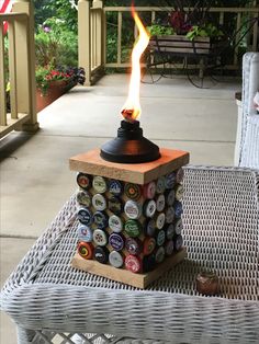 a bottle cap lamp sitting on top of a table next to a wicker chair