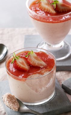 two desserts with strawberries in them on a table