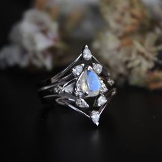 "This set of 3 rings features a Moonstone engagement ring with two diamond V bands. A pretty 7x5 mm pear cut rainbow moonstone, with accent diamonds forming a trillion, sitting on a split shank with diamond kites - this unique engagement ring is a perfect choice for your enigmatic other half, her mystic side which you just cannot fathom! Stack it with our versatile 3 pear diamond V rings to complete the look. These rings are crafted in solid 14k or 18k gold with natural diamonds and gemstones. * Celestial Stackable Moonstone Ring For Anniversary, Crescent Moonstone Ring For Anniversary, Crescent Moonstone Anniversary Ring, Celestial Silver Stackable Wedding Rings, Celestial Style Silver Stackable Wedding Rings, Silver Celestial Stackable Rings For Wedding, Celestial Silver Stackable Rings For Wedding, Stackable Moonstone Wedding Ring, Celestial Style Silver Stackable Rings For Wedding