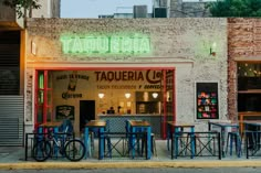 the outside of a restaurant with tables and chairs