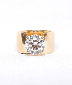 a yellow gold ring with a diamond in the center