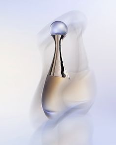 an abstract photo of a silver vase with a liquid dropper on the top and bottom