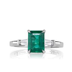 Chosen with precision, a mesmerizing green emerald stone takes center stage in this bespoke 1.80ct emerald cut green emerald engagement ring set in durable and luxurious platinum, radiating beauty and femininity. The center emerald is a GIA-certified 1.50ct stunning deep color green measuring an impressive 8.12x6.09mm. Flanked by two stunning and unforgettable tapered baguette cut diamonds on either side, totalling 0.30ct in E-F color and VS1-VS2 clarity, this masterpiece exudes a sense of timel Emerald Engagement Ring Green, Emerald Engagement Ring Set, Luxury Engagement Rings, Mark Broumand, Emerald Engagement, Baguette Cut Diamond, Emerald Stone, Emerald Engagement Ring, Deep Colors