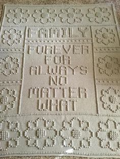 a white crocheted afghan with words written in the middle and numbers on it