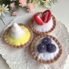 three small pies on a white doily with flowers in the backgroud