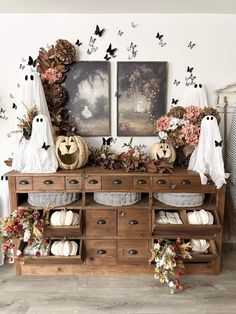 an old dresser is decorated for halloween with pumpkins and ghost decorations on the top