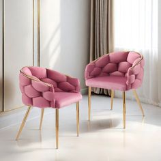 two pink chairs sitting next to each other in a room