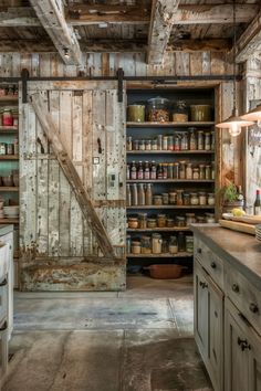 a rustic kitchen with an open door leading to the pantry