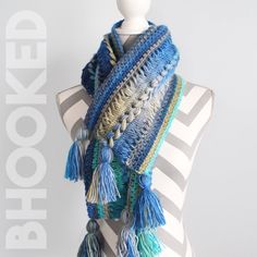 a blue and white scarf with tassels on top of a mannequin