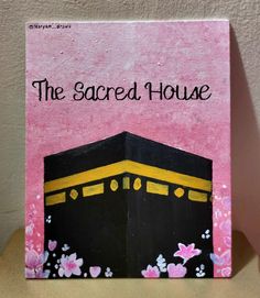 the sacred house book on a table with pink and yellow background, in front of a white wall