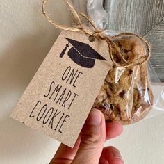 a hand holding a tag that says one smart cookie next to a bag of cookies