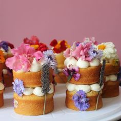 several small cakes with flowers on them sitting on a plate